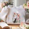 Picture of Embroidered Black Cat Chasing Butterfly Meadow Sweatshirt , Flower With Cat Hoodie, Black Cat And Wildflowers Sweatshirt, Cat Lover Shirt